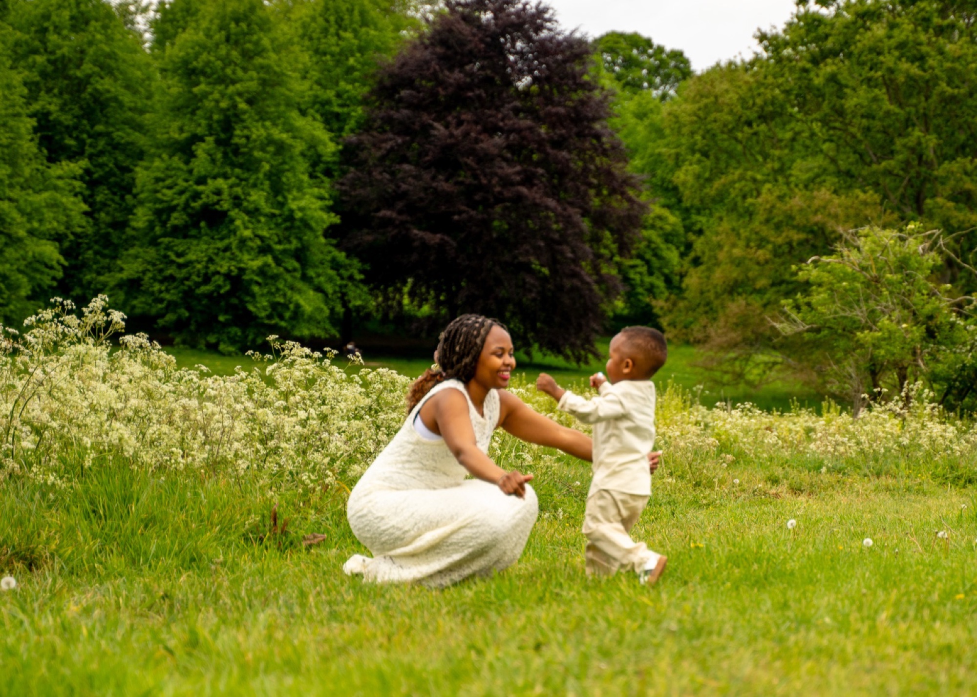 Natural portrait of a mother and her young son in green parkland